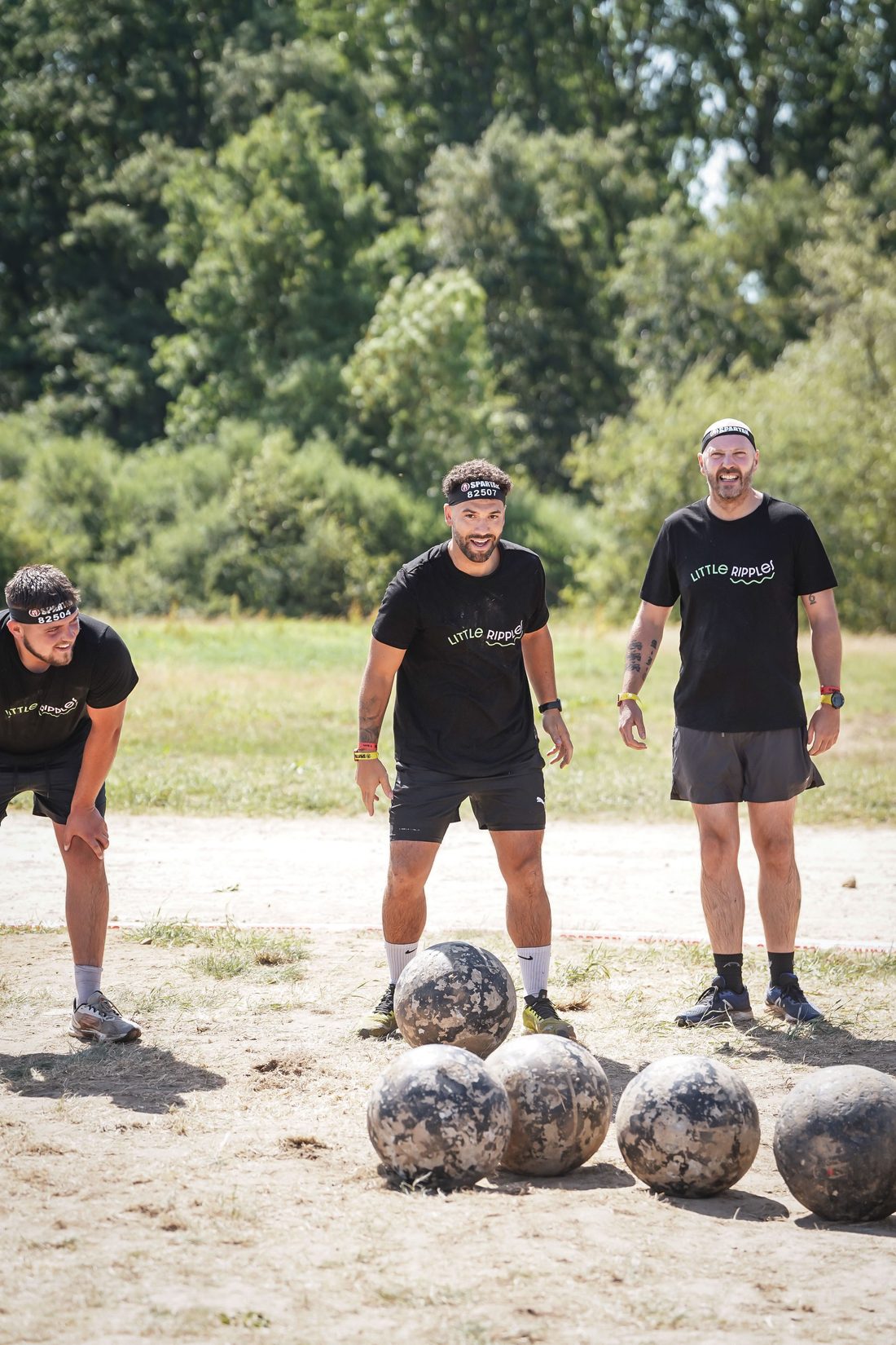 Three Little Ripples team members in branded shirts during an obstacle race