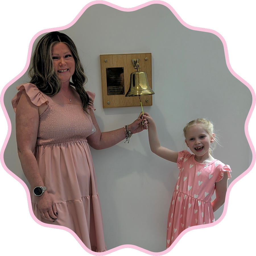A mother and her daughter ringing the end-of-treatment bell together